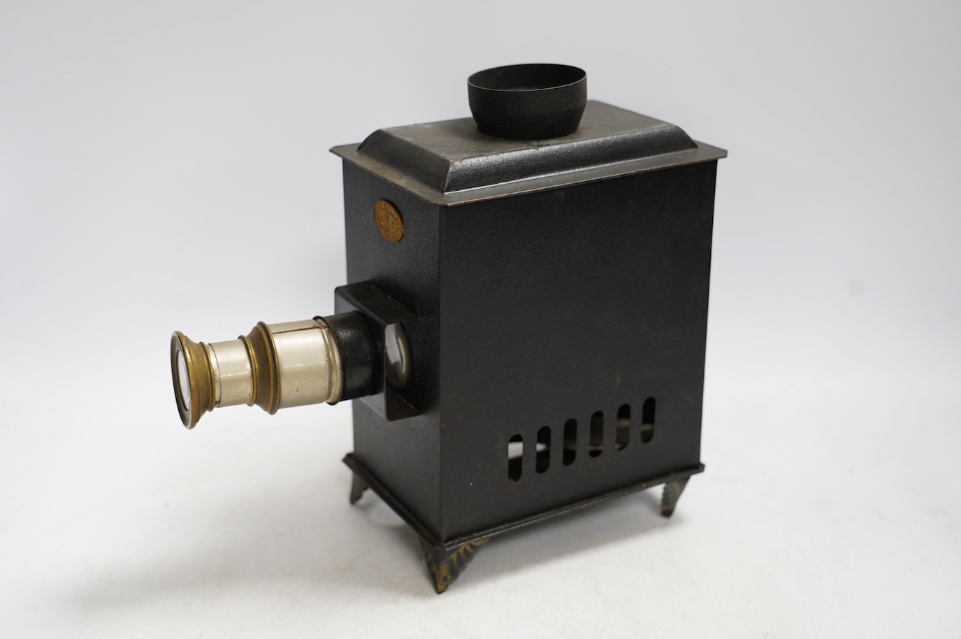 A late 19th century child's tinplate magic lantern with a selection of German slides, magic lantern 21cm high. Condition - fair to good